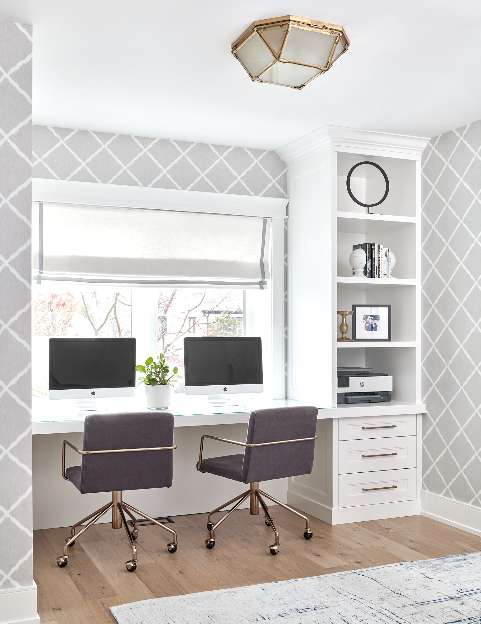 Office interior design project showing custom desk area with open shelving and two grey and gold swivel chairs