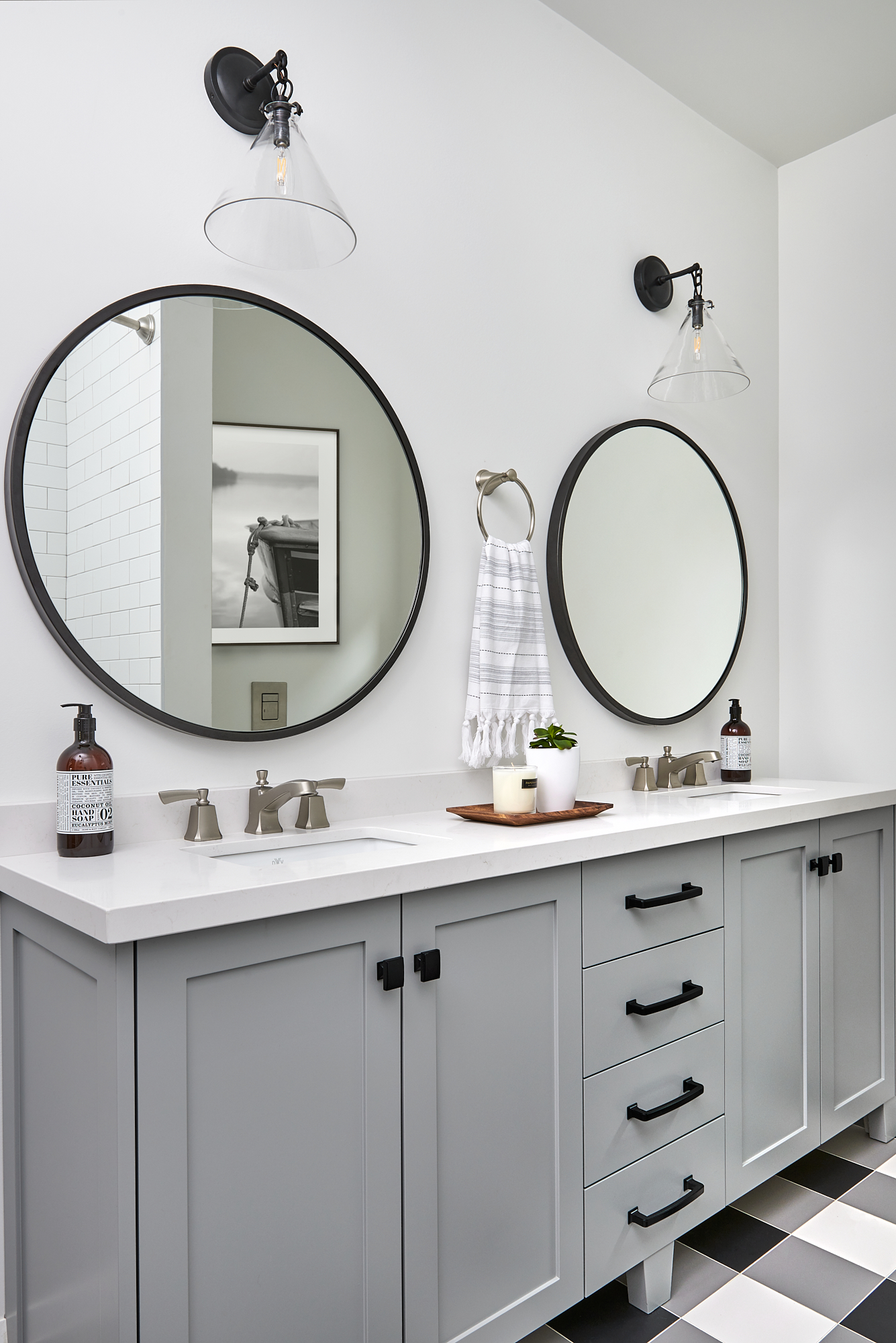 custom grey vanity with black hardware and round mirrors above