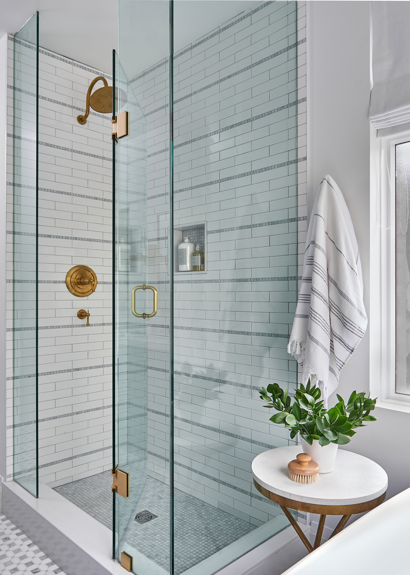 custom shower with beautiful tile detail and gold fixtures